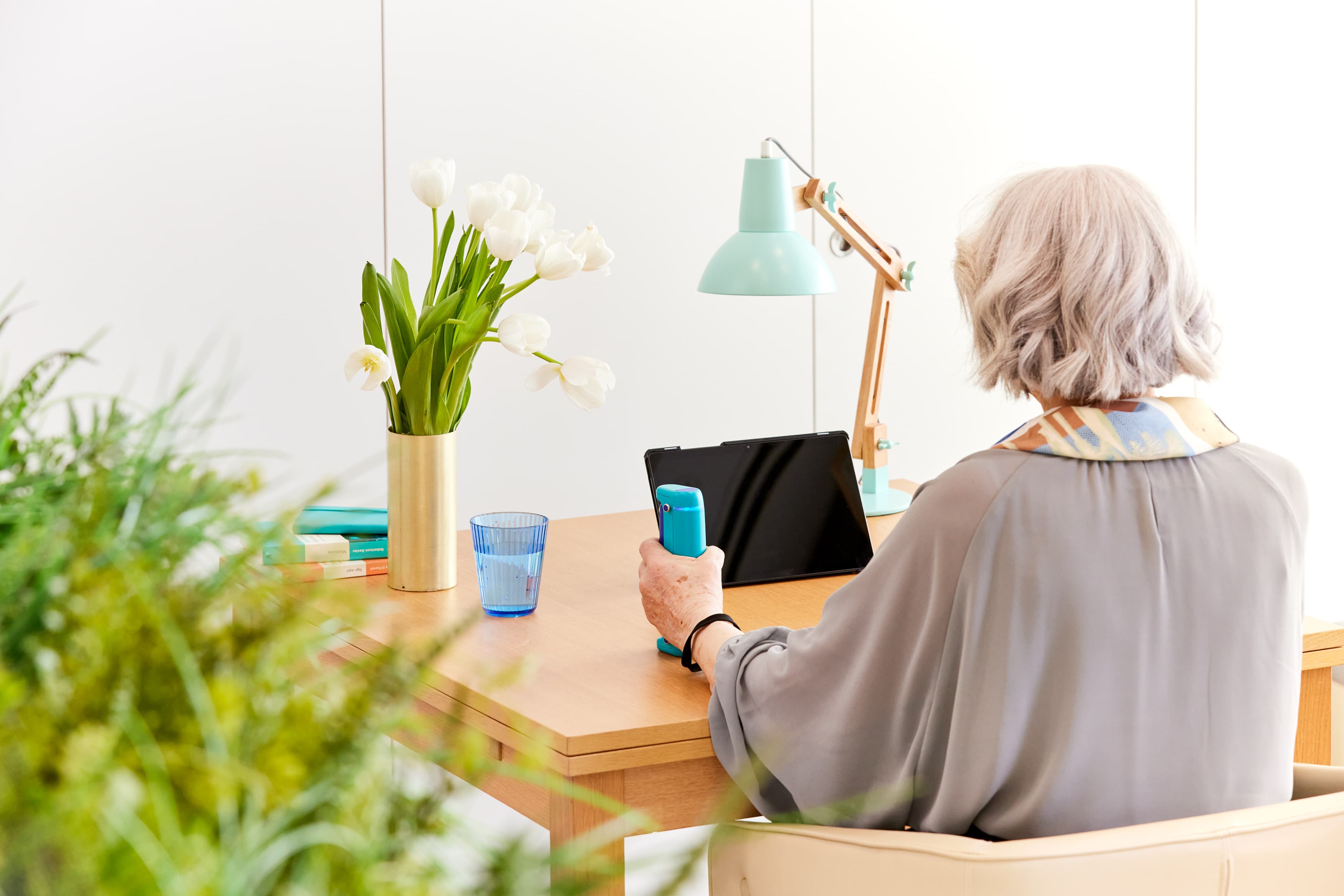 Older woman using GripAble sensor at home during care visit
