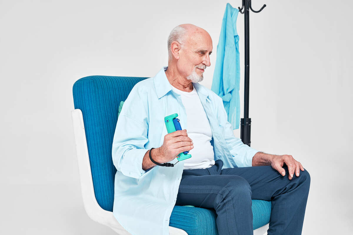 man sitting in a chair holding GripAble, fall risk assessment tool